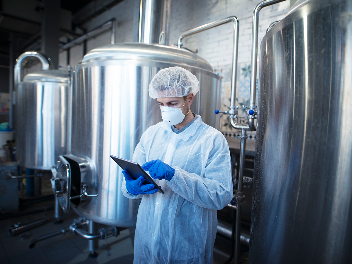 Técnico comprobando extintores y sistemas de seguridad en cocina industrial