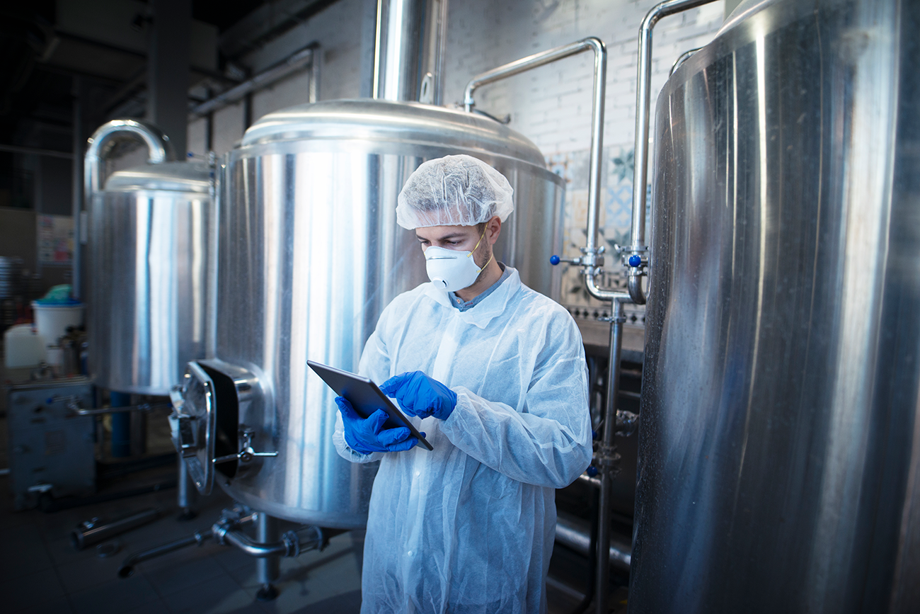 Técnico comprobando extintores y sistemas de seguridad en cocina industrial